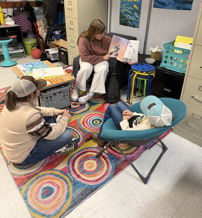 Three individuals engage collaboratively on a colorful rug in a cozy learning space, fostering warmth and inclusivity.