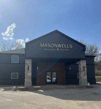 Modern "MasonWells Wellness Day Spa" building with dark exterior, stone accents; evokes calmness and relaxation.