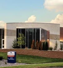 Modern health facility with glass windows, landscaped greenery, and a bright sky, instilling hope and confidence.