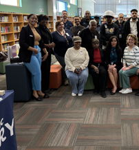 Diverse, smiling individuals in a bright library setting, embodying camaraderie, community, and positivity.