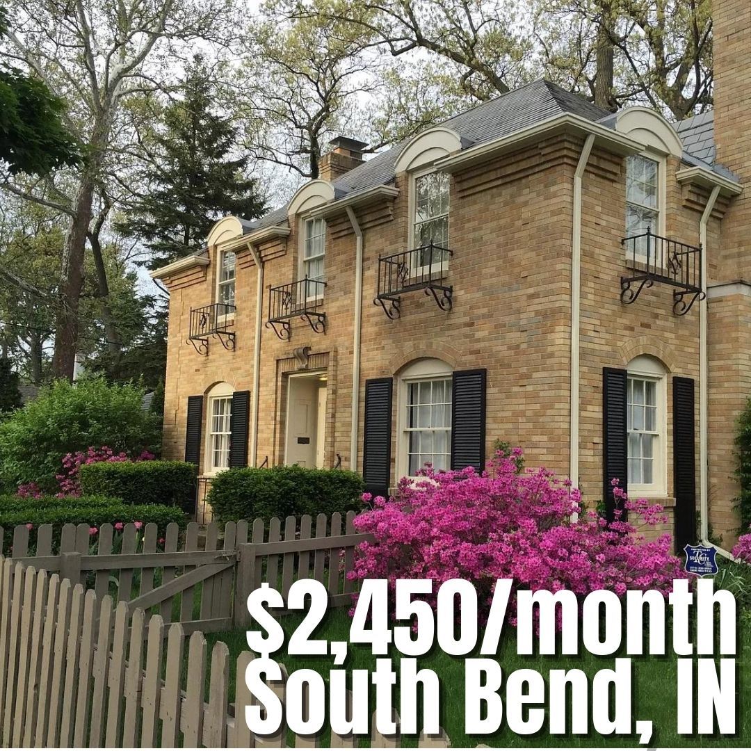Charming brick house with a garden of pink flowers, evoking warmth, nostalgia, and inviting suburban lifestyle aspirations.