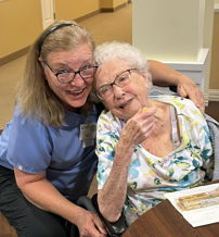Two women, one older and one younger, share a warm, joyful moment in a cozy indoor setting, showcasing love and connection.