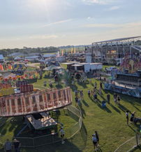 A vibrant fair scene with colorful rides, game booths, and food vendors, radiating joy, community, and a festive atmosphere.