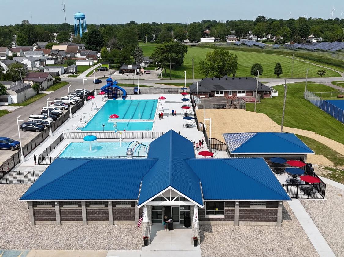 A vibrant community pool with slides, loungers, and picnic areas, evoking joy, relaxation, and summer fun.