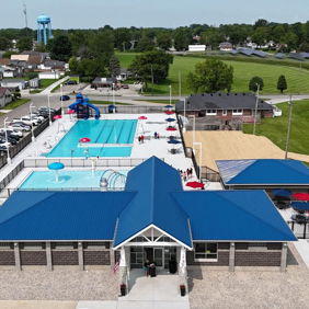 A vibrant community pool with slides, loungers, and picnic areas, evoking joy, relaxation, and summer fun.