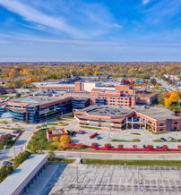 Vibrant autumn campus with modern brick and glass buildings, surrounded by colorful trees, evoking tranquility and warmth.