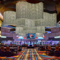 Vibrant casino interior with stylish lighting, colorful carpet, slot machines, and a lively social atmosphere evoking excitement.