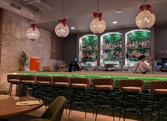 Modern bar with sleek design, warm lighting, inviting seating, and festive touches, creating a cozy social atmosphere.