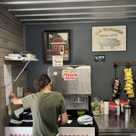 Cozy food counter with a worker, checkered tablecloth, snacks, and a warm, inviting atmosphere for casual dining.