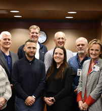 A group of smiling professionals poses together, exuding camaraderie and a positive, collaborative workplace atmosphere.