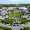 Aerial view of a well-planned residential area with circular roads, green spaces, and organized buildings, evoking tranquility.