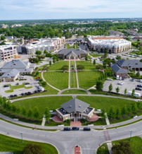 Aerial view of a well-planned residential area with circular roads, green spaces, and organized buildings, evoking tranquility.