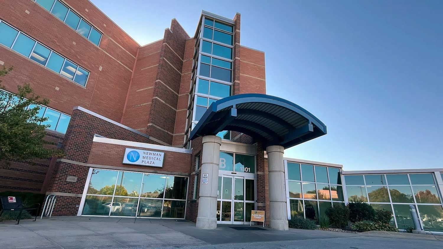 Modern building with large glass windows and curved awning, suggesting professionalism, openness, and a welcoming atmosphere.