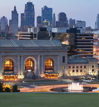 Dusk cityscape with modern skyscrapers, historic architecture, a lit museum, and a serene fountain, blending vibrancy and tranquility.