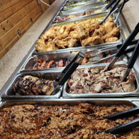 Buffet spread of barbecue meats and sides in warm lighting, evoking excitement and nostalgia for communal dining.