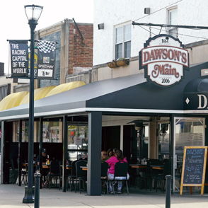 Cozy restaurant "Dawson's on Main" features a welcoming exterior and lively diners, evoking warmth and community connection.