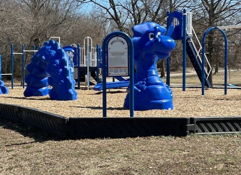 Colorful, well-maintained playground with blue equipment, climbing structures, and slides in an inviting outdoor setting.