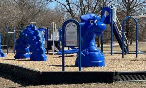 Colorful, well-maintained playground with blue equipment, climbing structures, and slides in an inviting outdoor setting.