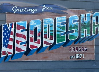 Vibrant mural featuring "Greetings from NEODESHA" with colorful letters reflecting local pride and history in Kansas.