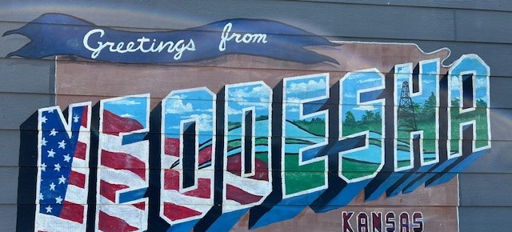 Vibrant mural featuring "Greetings from NEODESHA" with colorful letters reflecting local pride and history in Kansas.