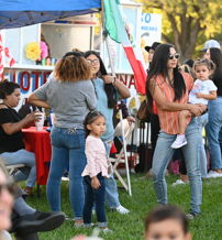 Lively outdoor gathering with diverse people, joyful interactions, colorful decor, and a festive, family-friendly atmosphere.