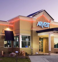 A modern bank building with welcoming lighting, clean lines, and flags, evoking trust, security, and a cozy atmosphere.
