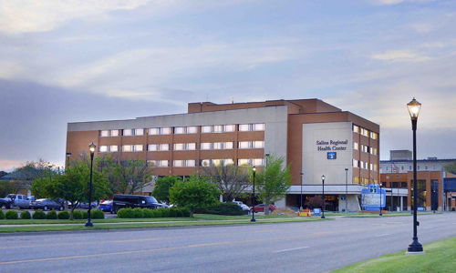 Modern hospital along a tree-lined road, reflecting soft light, evokes tranquility, hope, and a welcoming healing atmosphere.
