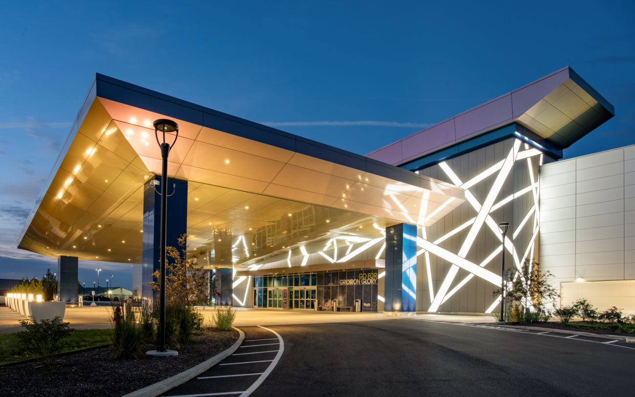 Modern building with sleek architecture, vibrant lights, and a serene dusk backdrop, evoking excitement and curiosity.