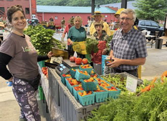 A lively farmers' market scene with people engaging, showcasing joy, community, and fresh produce under a vibrant shelter.