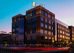 Modern building with glass and brick, illuminated at twilight, evokes calmness and vibrancy during a serene dusk.