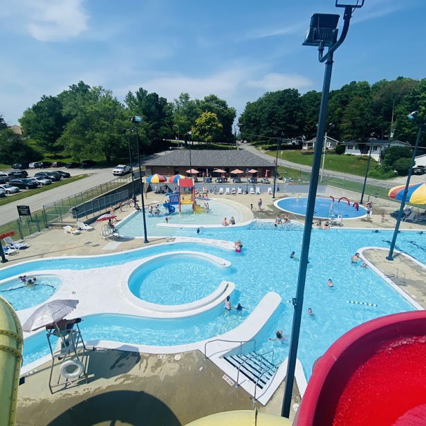 A vibrant water park scene with pools, slides, families, and colorful umbrellas, evoking joy and summer fun.