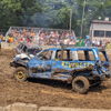 Demolition derby scene with damaged cars in a muddy arena, crowd excitedly watching the thrilling competition.