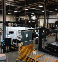 Spacious industrial workshop with machinery, bright lights, evoking feelings of efficiency, industriousness, and focus.