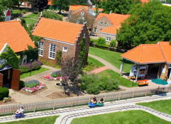 Charming village scene with colorful houses, lush gardens, and people enjoying a sunny day, evoking nostalgia and tranquility.