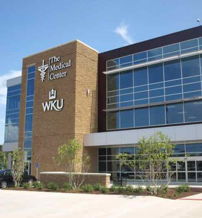 Modern WKU medical center with glass windows, landscaped areas; evokes trust, hope, and community engagement.