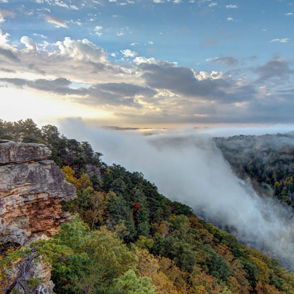 A tranquil landscape features a waterfall, lush greenery, and autumn colors, evoking peace and awe in nature's beauty.