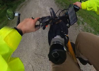 A cyclist in a yellow jacket navigates a lush, rainy path, embodying adventure, tranquility, and resilience in nature.