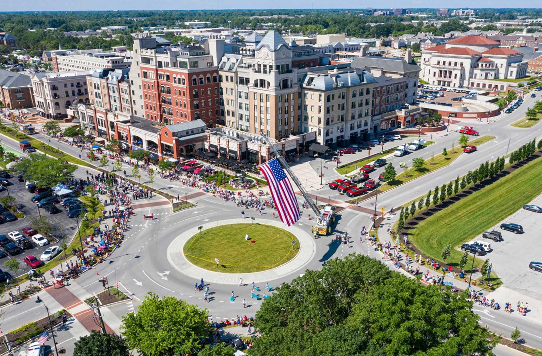 A vibrant aerial view of a bustling downtown with an American flag, showcasing community celebration and joy.