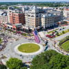 A vibrant aerial view of a bustling downtown with an American flag, showcasing community celebration and joy.