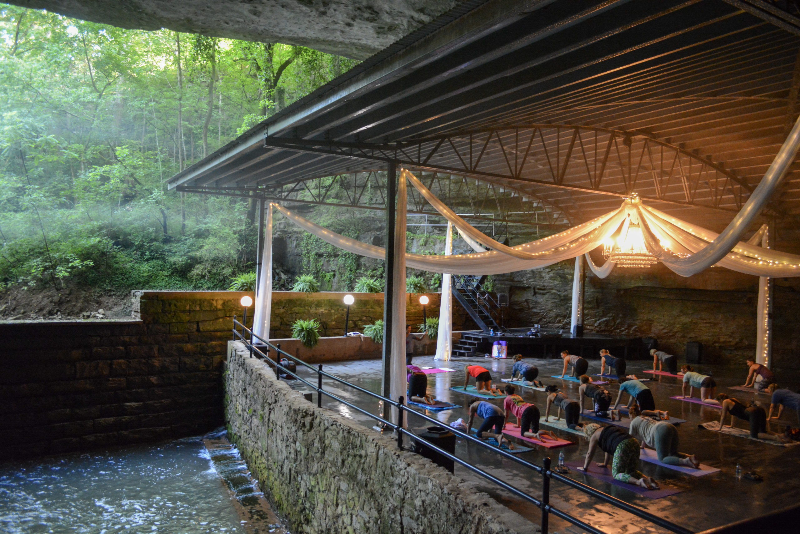 A peaceful outdoor yoga space with mats, soft lighting, and lush greenery, evoking relaxation and community.