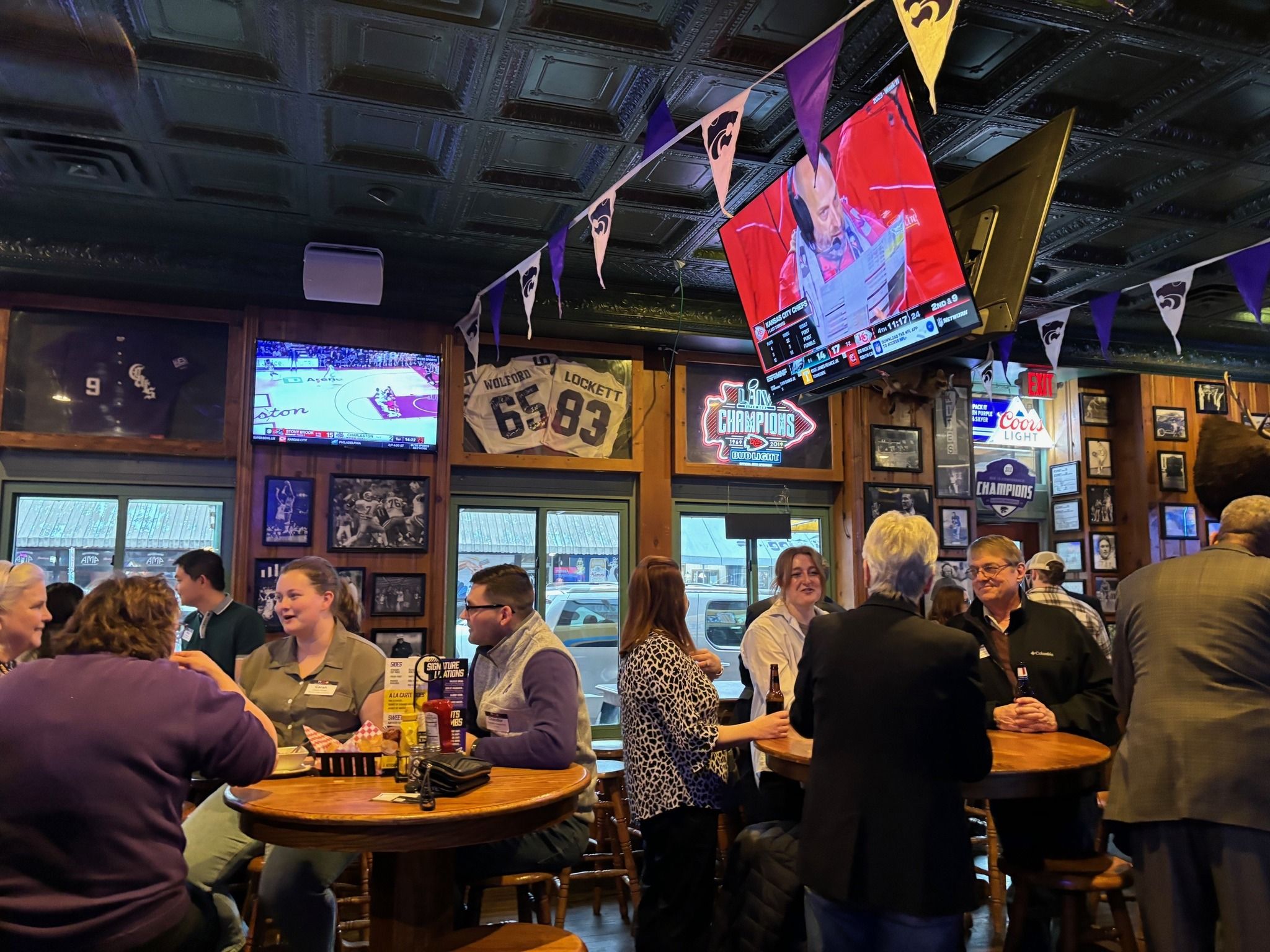 Lively bar scene with groups socializing, warm lighting, sports on screens, creating a welcoming atmosphere of joy and camaraderie.