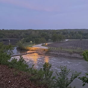 Serene landscape with a winding river, lush greenery, and soft twilight colors, evoking calm and tranquility.
