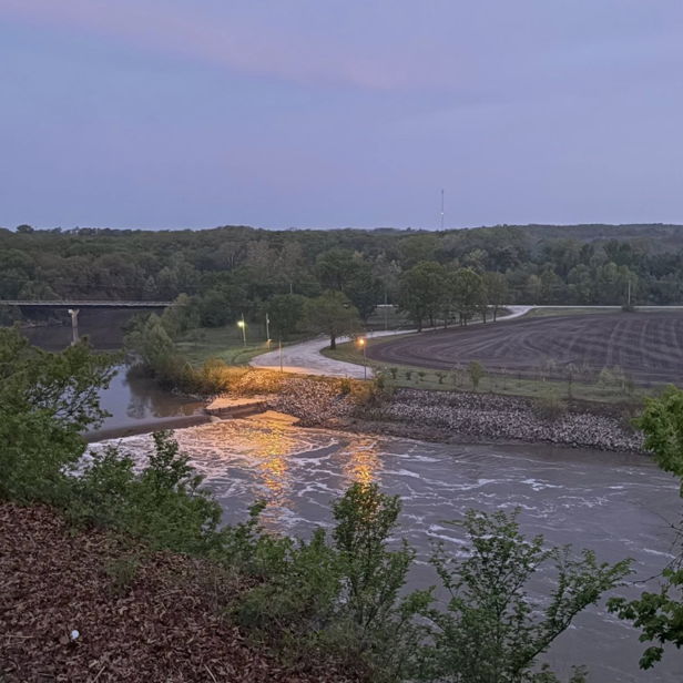 Serene landscape with a winding river, lush greenery, and soft twilight colors, evoking calm and tranquility.