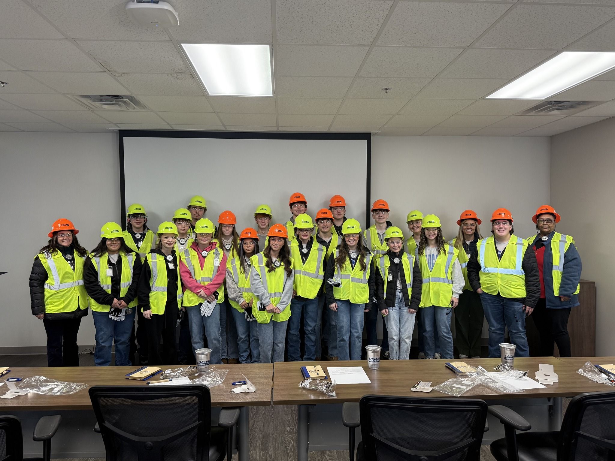 Group of people in bright yellow vests and colorful hard hats in a professional setting, conveying teamwork and safety.