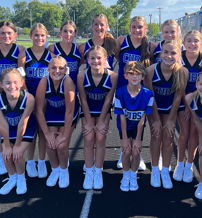 Cheerleaders in blue and black uniforms smile together on a track field, exuding joy, camaraderie, and team spirit.