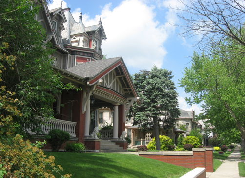 Charming house with gabled roof, lush landscape, bright sky, evoking tranquility and nostalgia in a peaceful neighborhood.