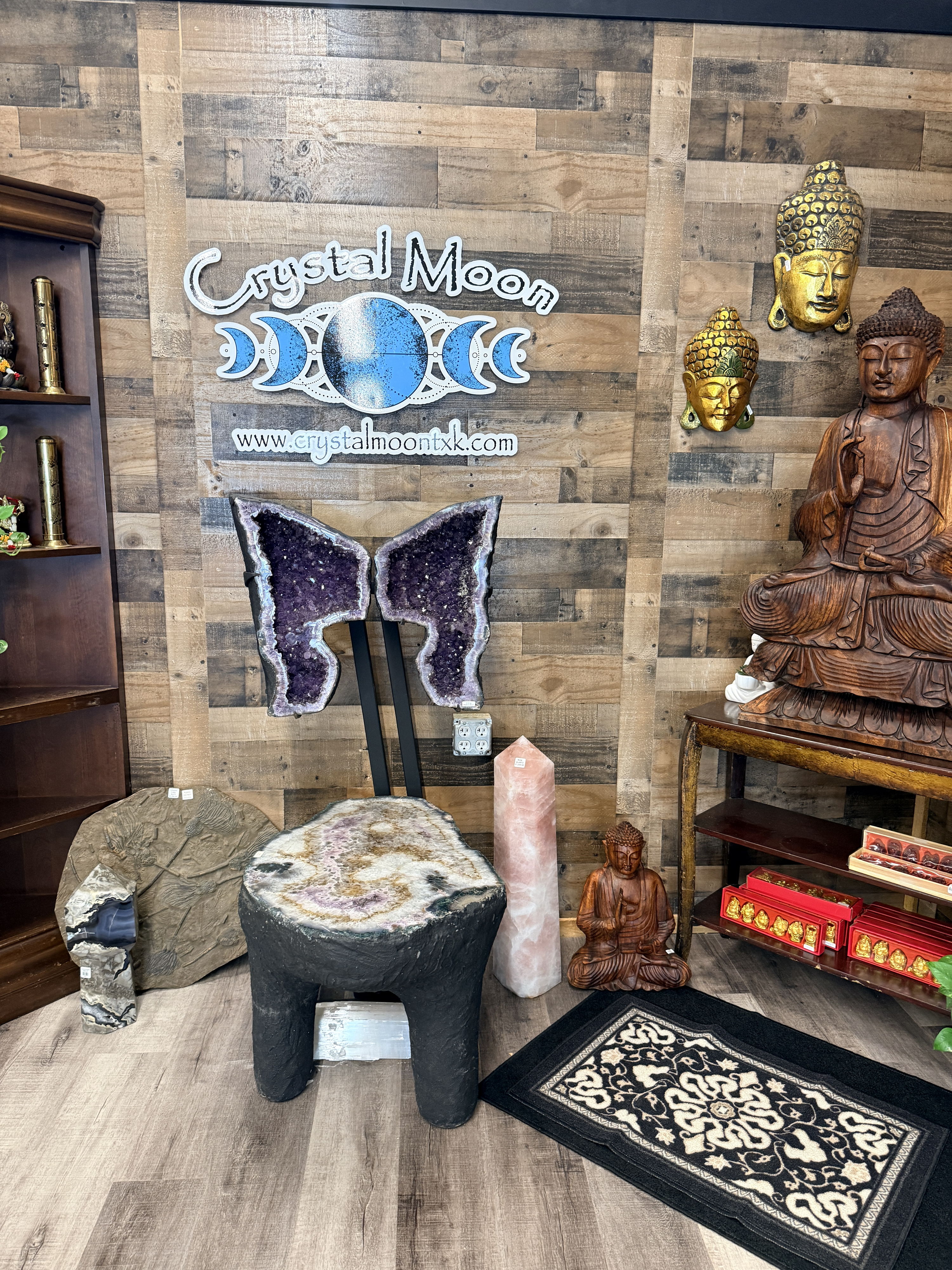 A calming crystal shop decorated with Buddha statues, vibrant crystals, and warm wooden elements, promoting serenity and wellness.