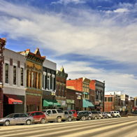 Vibrant street scene with colorful buildings, ornate facades, and a lively atmosphere under a bright blue sky.