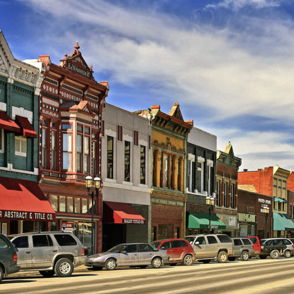 Vibrant street scene with colorful buildings, ornate facades, and a lively atmosphere under a bright blue sky.