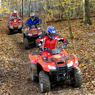 Three individuals ride ATVs through a colorful autumn forest, showcasing adventure, safety, and a sense of camaraderie.